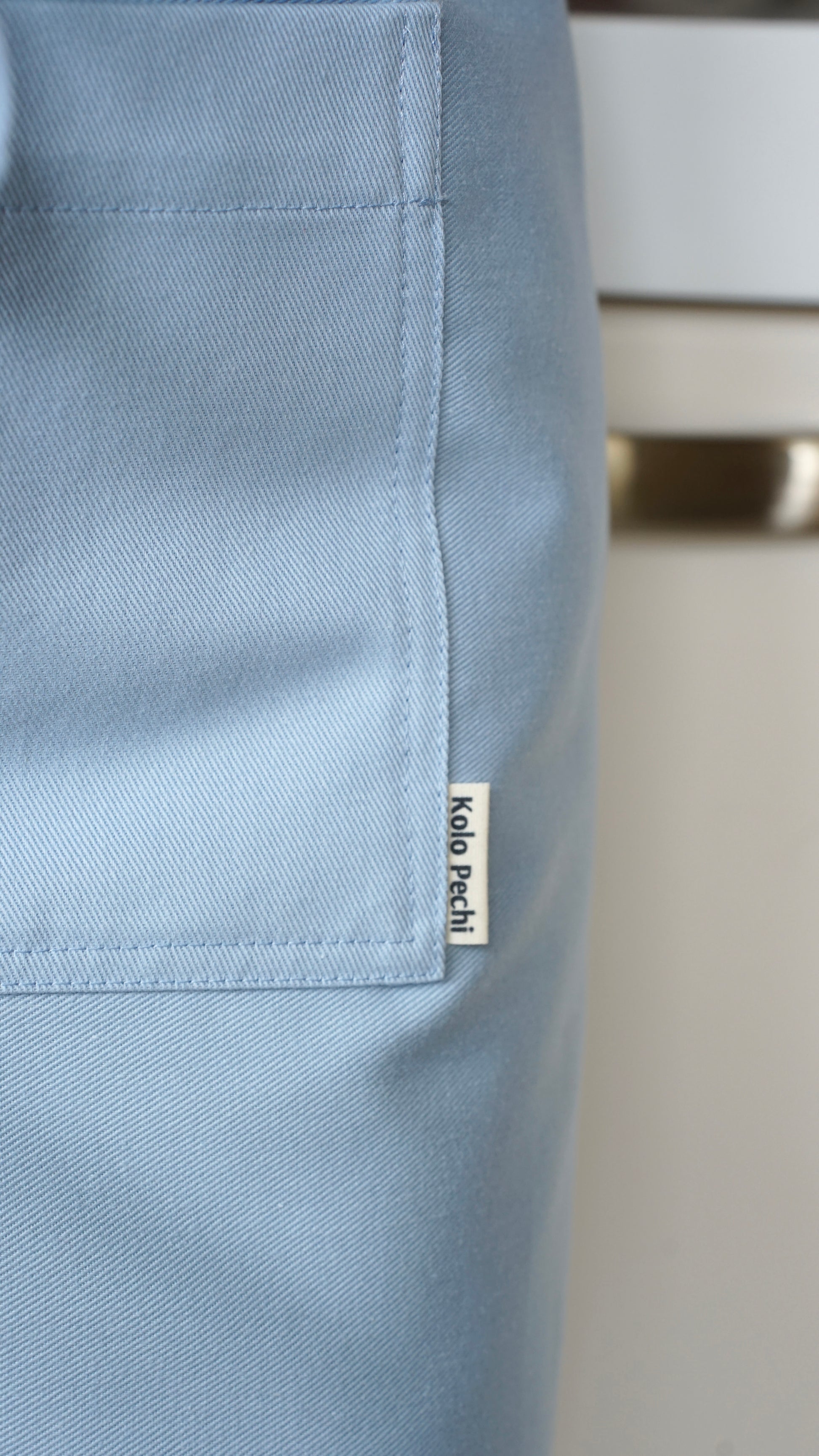  Synevyr Bib Apron — close-up of front pocket with logo Kolo Pechi, natural cotton