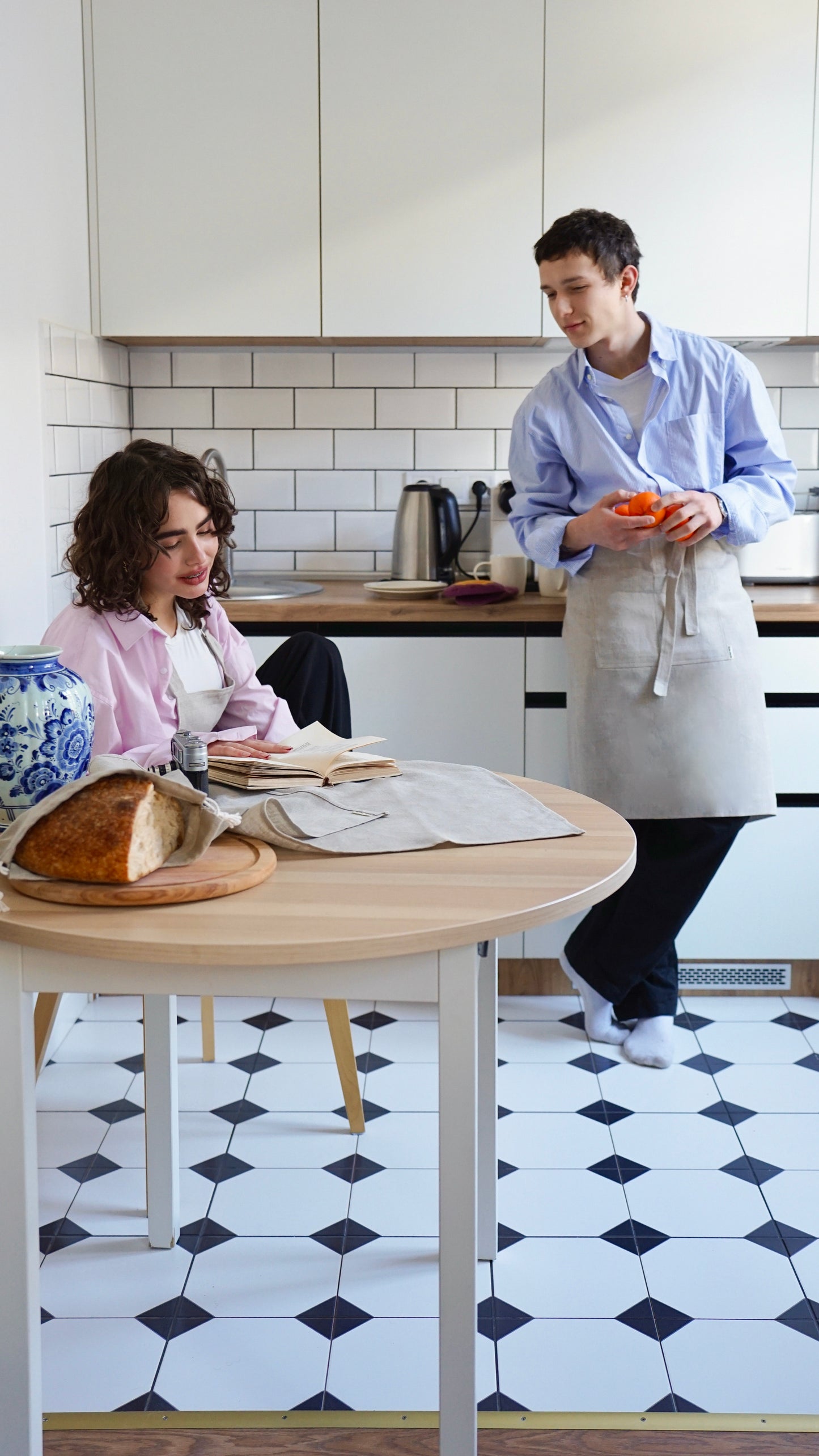 Two people in a kitchen with linen aprons — Polissia collection by Kolo Pechi