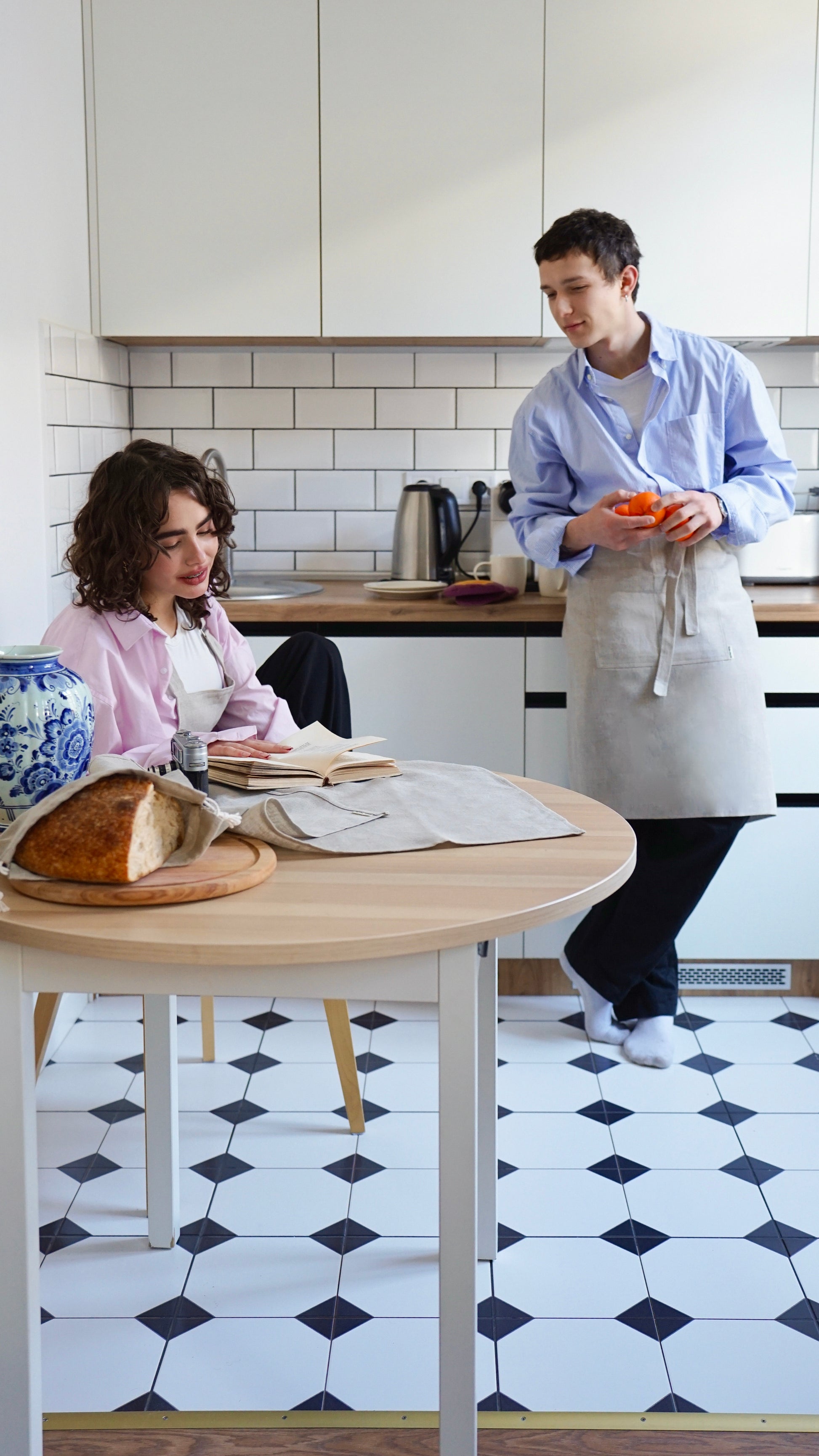 Two people in a kitchen with linen aprons — Polissia collection by Kolo Pechi