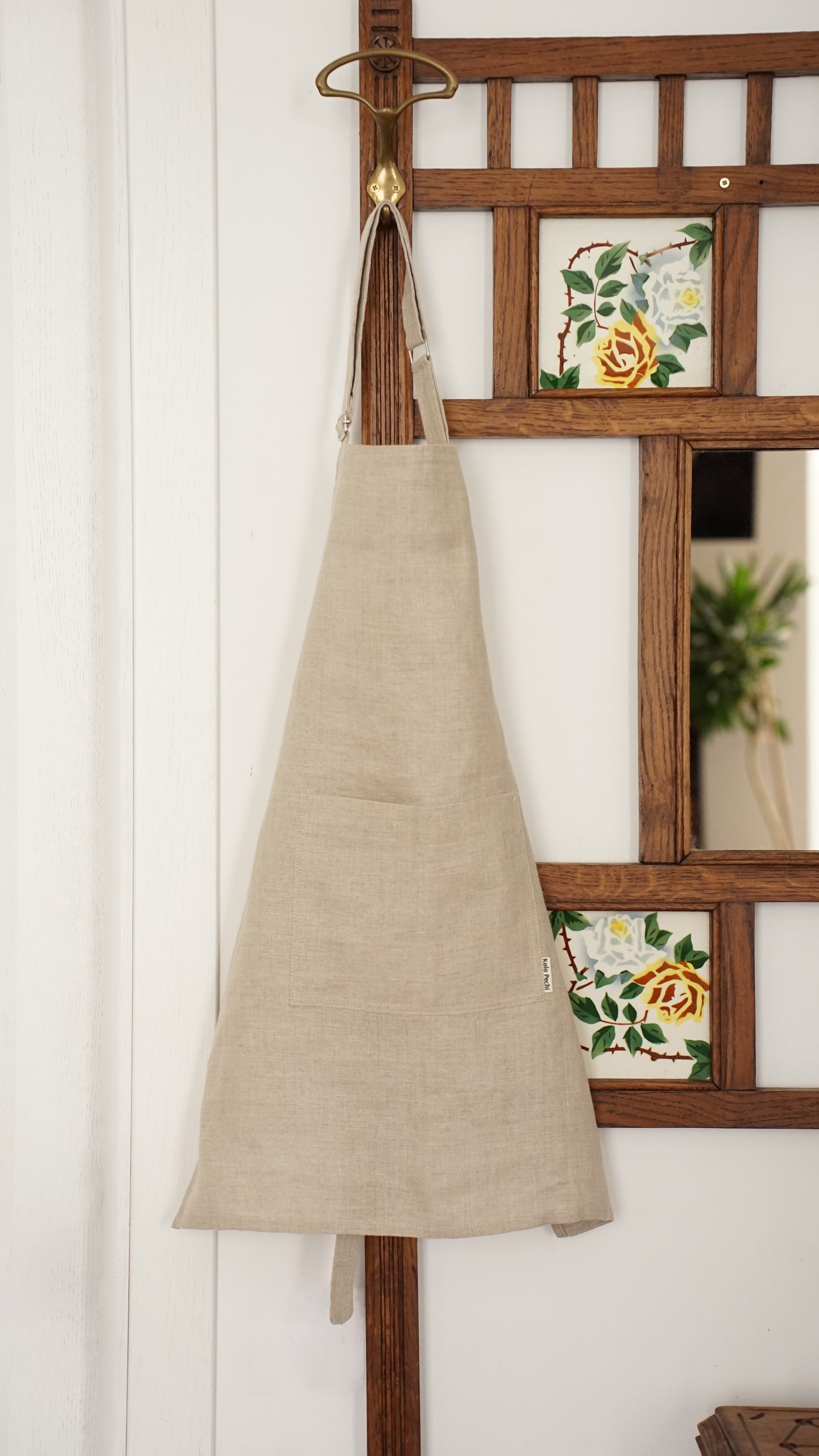 Beige linen apron hanging on a wooden rack — Polissia collection by Kolo Pechi