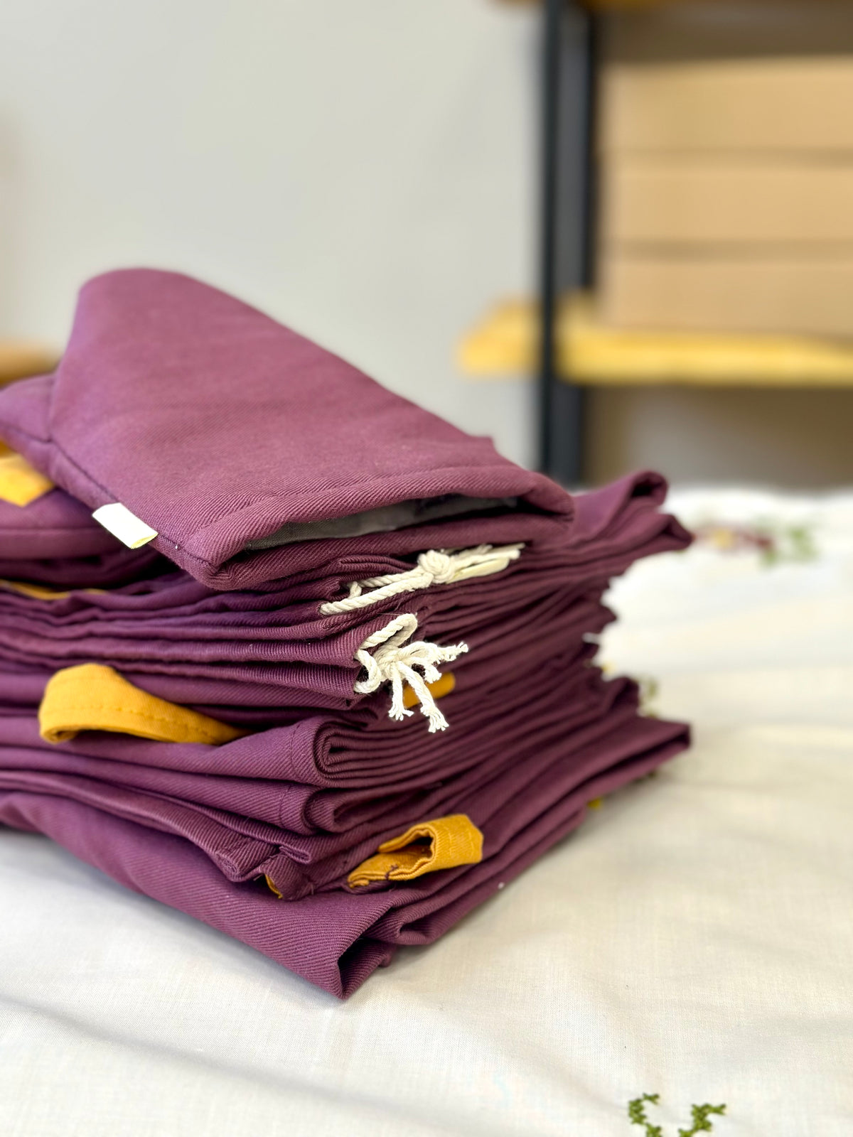 A stack of folded purple fabric items from The Kolo Pechi Borscht Collection 